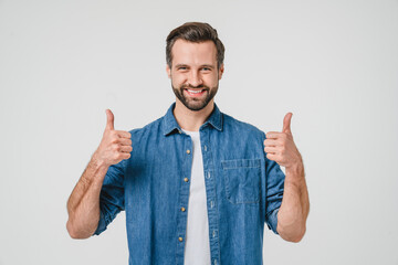 Positive caucasian young man in denim casual clothes showing thumbs up for good quality checkup,...