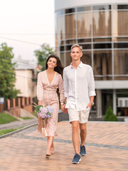 loving couple with flowers walking around the city