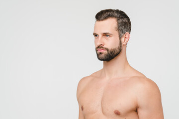Fototapeta premium Side view portrait of caucasian young handsome shirtless naked man with beard isolated in white background. Male beauty body care concept