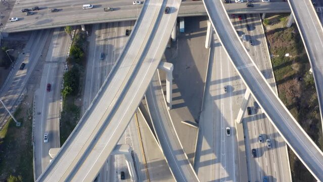 Aerial shot of elevated road junction. Drone footage of top view of Highway road junctions. The Intersecting freeway road overpass. Overhead Shot of Judge Pregerson Highway showing multiple Roads. 
