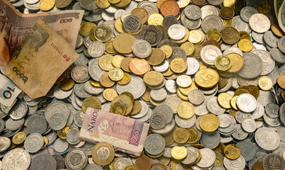 Lots of different coins, heap of money background, donation box inside detail, closeup, world currencies, nobody. Collecting large amounts of money, funds collection simple concept, no people