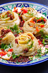 Traditionelles afghanisches Ay Khanom gedünstet mit Hackfleisch, Paprika und Joghurt als close-up auf einem klassischen Teller