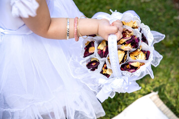 Rose Petal confetti in white basket in the hand of small flower girl