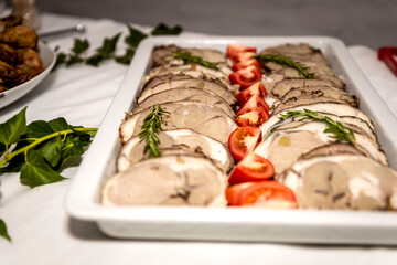 Roasted meat cold cut slices on a white platter