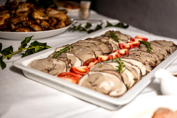 Roasted meat cold cut slices on a white platter