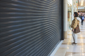 Stores show case in shopping mall closed due to sanctions, boycott and embargo, mass market cloth shops work stoppage with closed storefronts, retail business suspension and brands leaving market - obrazy, fototapety, plakaty
