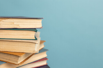 Stack of old books on the blue background. World Book Day. Literacy day. Copy space