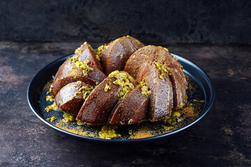 Exotically bundt marble passion fruit rum cake with icing sugar glaze, fresh fruit pulp topping and muscovado brown sugar served as close-up on a plate with copy space