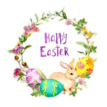 Easter wreath with bunny, colored eggs in grass, flowers. Circle frame with text Happy Easter . Watercolor