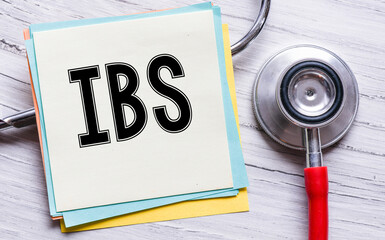 IBS written on a piece of paper next to the stethoscope.