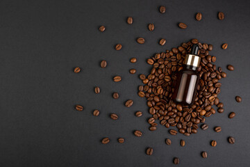 Brown bottle with dropper with a beauty serum on a black background on coffee beans. Glass...