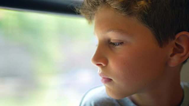 Young boy travelling by train looking out window