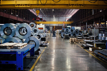 Metalworking factory production line. Rolls of steel and metal profiled parts in workshop