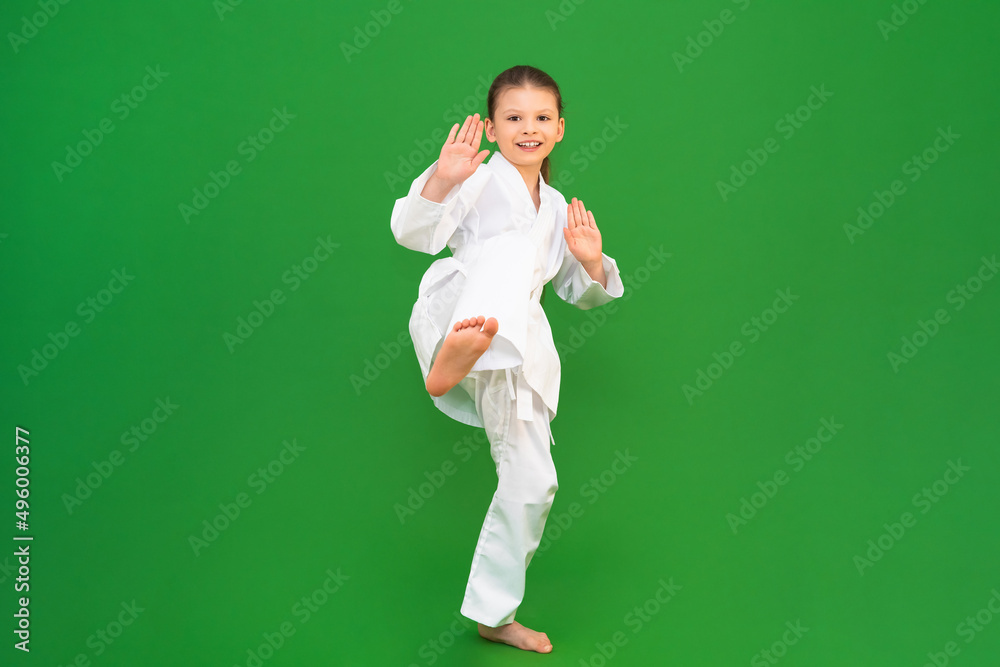 Wall mural A child in a white kimono, karate for child development.