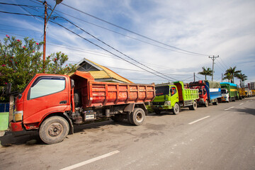 Obraz premium Trucks queue to refuel near a gas station in Palu City, Central Sulawesi, Indonesia. These trucks deliver various goods to cities in Central Sulawesi Province.