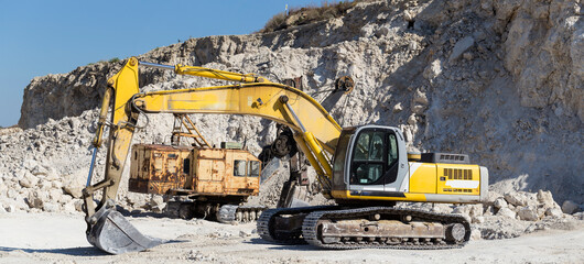 Yellow excavator - digging machine for digging and dumping the soil. Work in the quarry. © Piotr