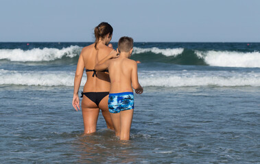 Holidaymakers, on the Black Sea coast. People sunbathe on the beach and swim in the sea. Family idyll.