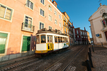 Fototapeta na wymiar Sunny street of Lisbon with blurry classic tram 28 in motion. Portugal 