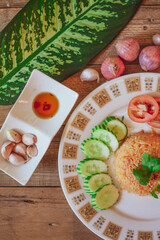 Fried Rice with Fried Egg Put on the wooden table and the tomatoes, cucumbers, garlic, shallots