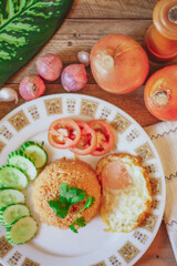 Fried Rice with Fried Egg Put on the wooden table and the tomatoes, cucumbers, garlic, shallots