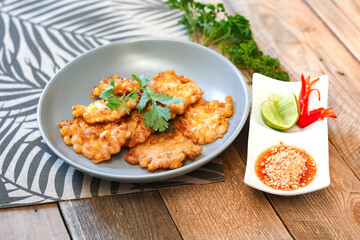 Corn Fritters With chili sauce placed on a wooden table