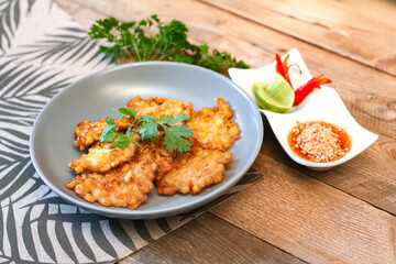 Corn Fritters With chili sauce placed on a wooden table