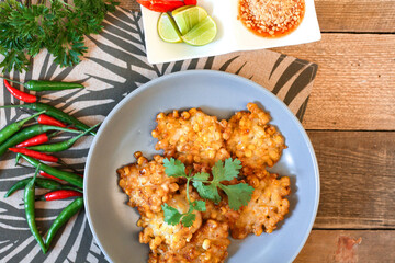 Corn Fritters With chili sauce placed on a wooden table