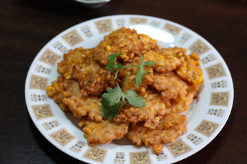 Corn Fritters With chili sauce placed on a wooden table