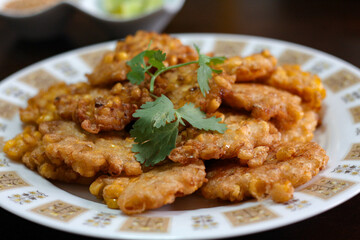 Corn Fritters With chili sauce placed on a wooden table