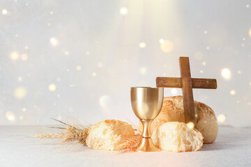Chalice of wine with bread and cross on light background. Holy Communion concept - obrazy, fototapety, plakaty
