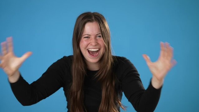 Portrait of frustrated, irritated sad angry young brunette woman 20s wears black shirt scream isolated on pastel plain blue background studio