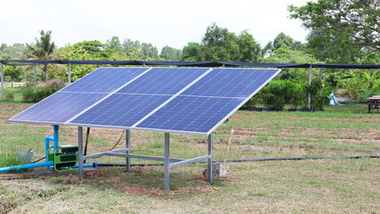 Solar panels and water pumps. Photovoltaic Panel for pumps to supply water to agricultural plots on the background of green plants with copy space. Selective focus