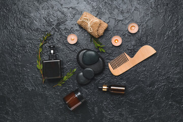 Fototapeta na wymiar Bathing supplies with cosmetics and spa stones on dark background