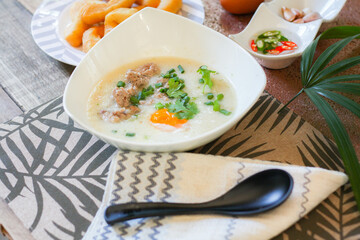 Chinese style porridge or porridge and fried dough stick or fried dough stick or donut or fried bread placed on a wooden table. Thai street food is called 