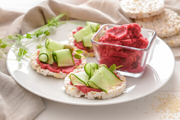 Plate with crispbreads and tasty hummus on table