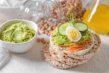Crispbreads with tasty hummus on white background