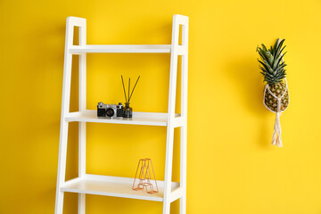 Shelf unit with camera and decor near color wall