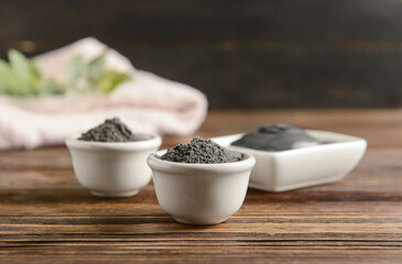 Bowls of activated carbon powder for facial mask on wooden table