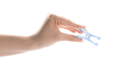 Female hand with plastic clothes pin on white background