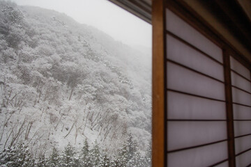 Mountain covered with snow in Japan through Japanese shoji window