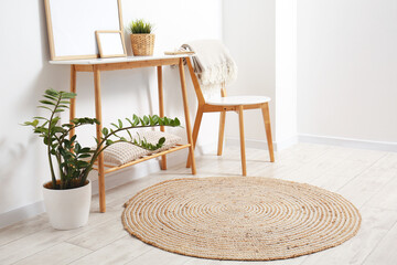 Wooden chair, table and wicker rug in light room