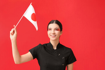 Beautiful young woman with flag of Japan on color background