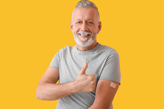 Mature man with applied nicotine patch showing thumb-up on color background. Smoking cessation