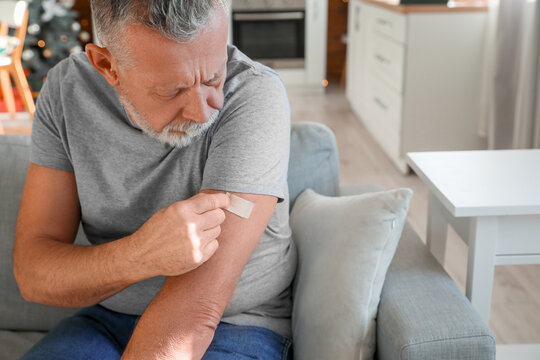 Mature man with applied nicotine patch at home. Smoking cessation