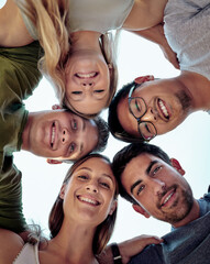 Putting our heads together. Low angle portrait of a young group of friends standing outside in a huddle.