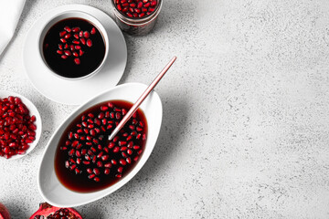 Bowls of pomegranate molasses on light background