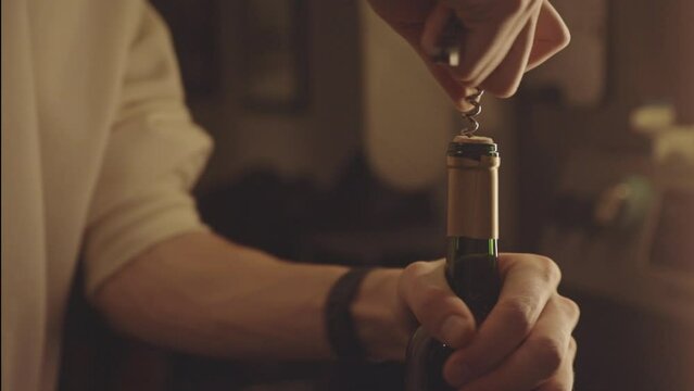 Man Opening Wine Bottle With Corkscrew. close up