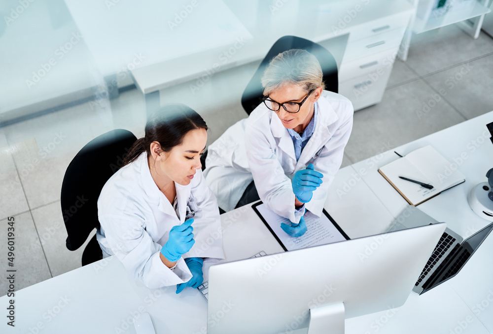 Poster science is about expanding the whole world. shot of two scientists working together on a computer in