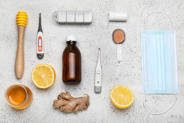 Obraz na płótnie Canvas Medications for sore throat, lemons, honey, medical mask and thermometers on light background