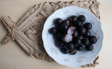 jaboticabas in a basket on wooden table